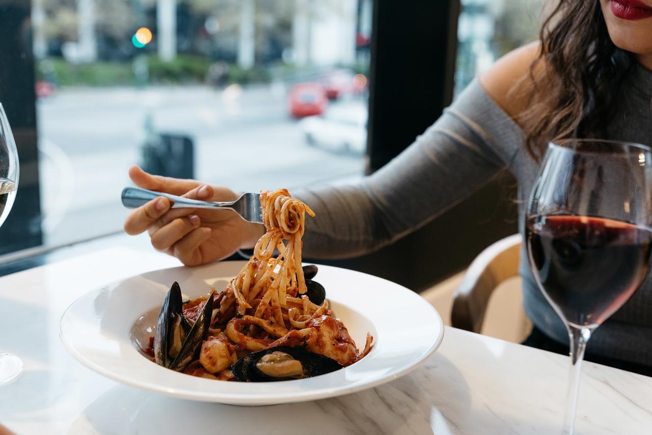 Art Series - The Chen Бокс-Хилл Экстерьер фото A woman eating a pasta dish